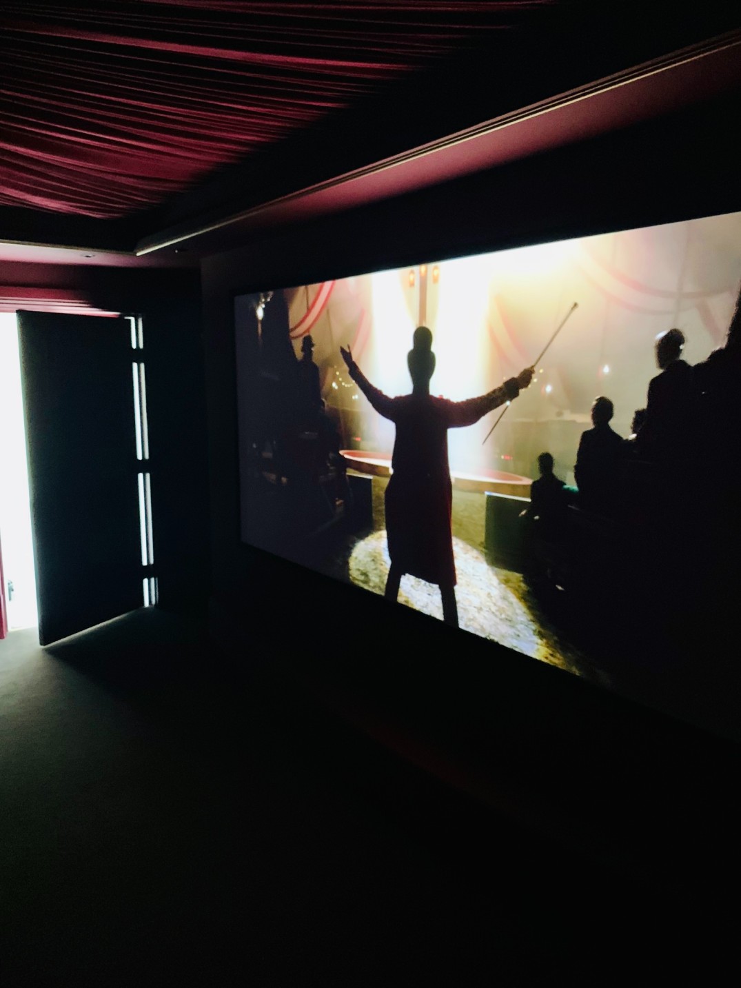 Home cinema room showcasing projector screen with movie showing