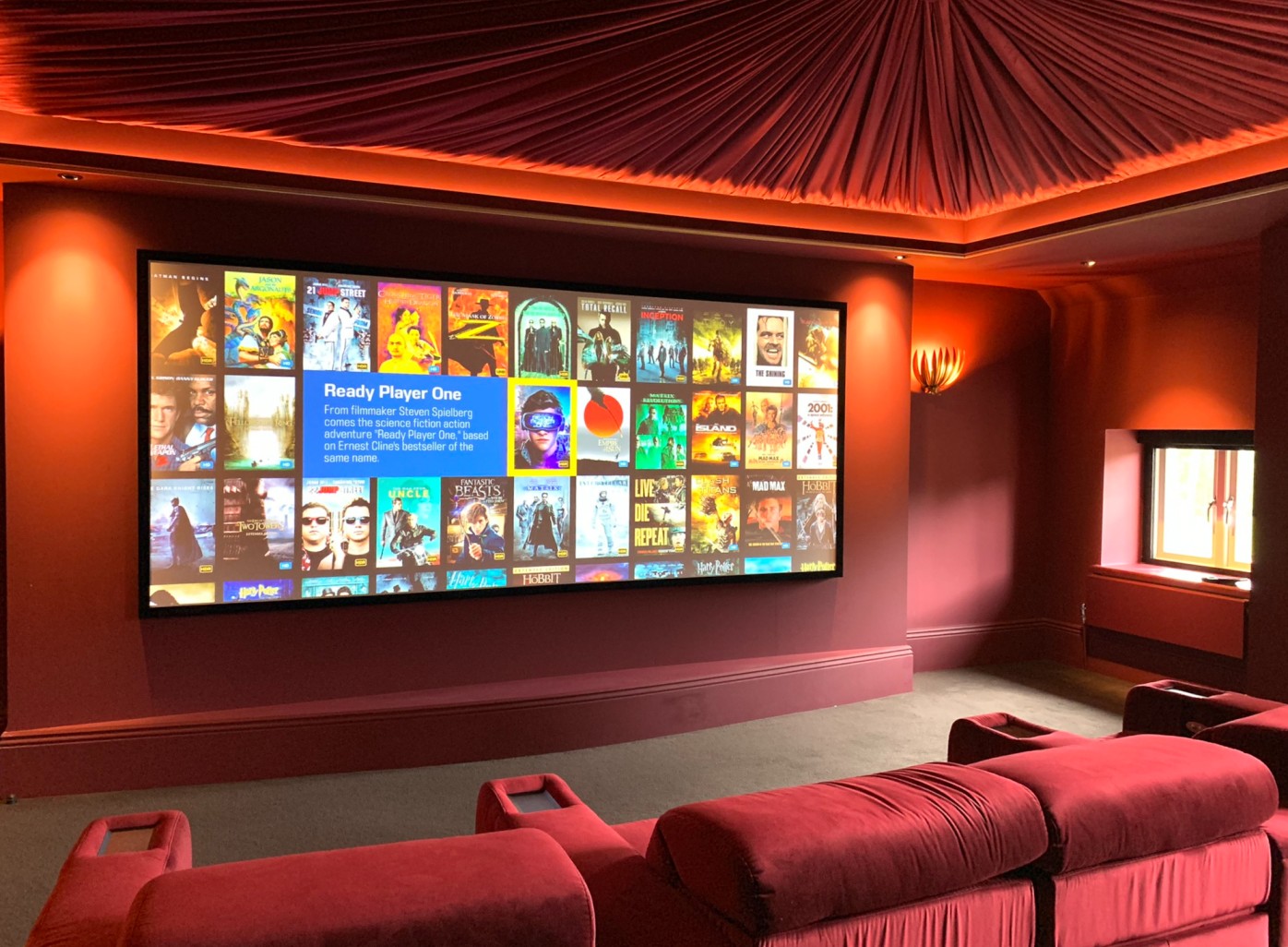 Cinema room showcasing projector screen, lighting, and cinema chairs