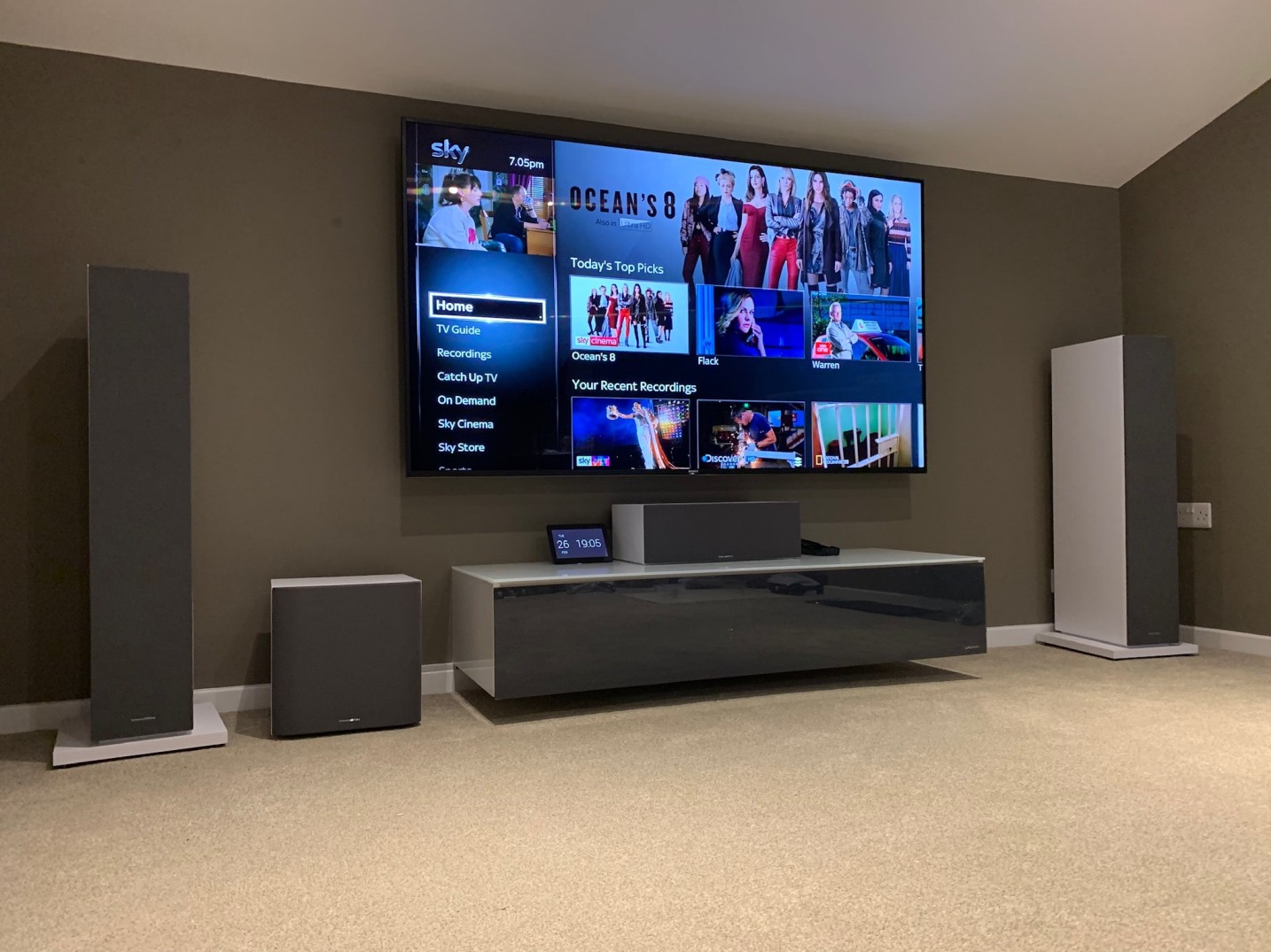 Home cinema set-up with multi-channel speaker system, Control4 panel and 4K TV