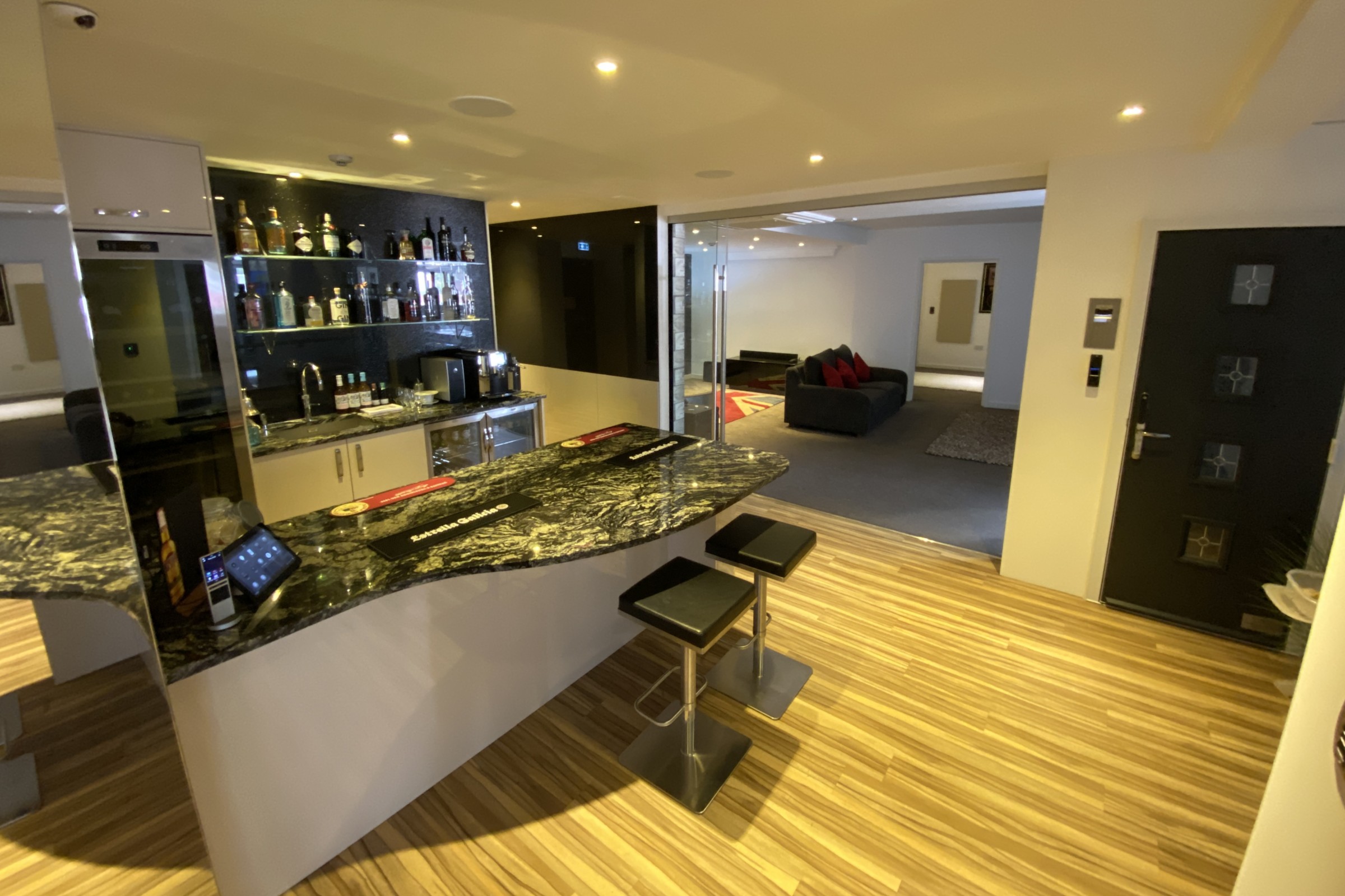 Smart home bar area with built-in cooling appliances and front door with keypad security options