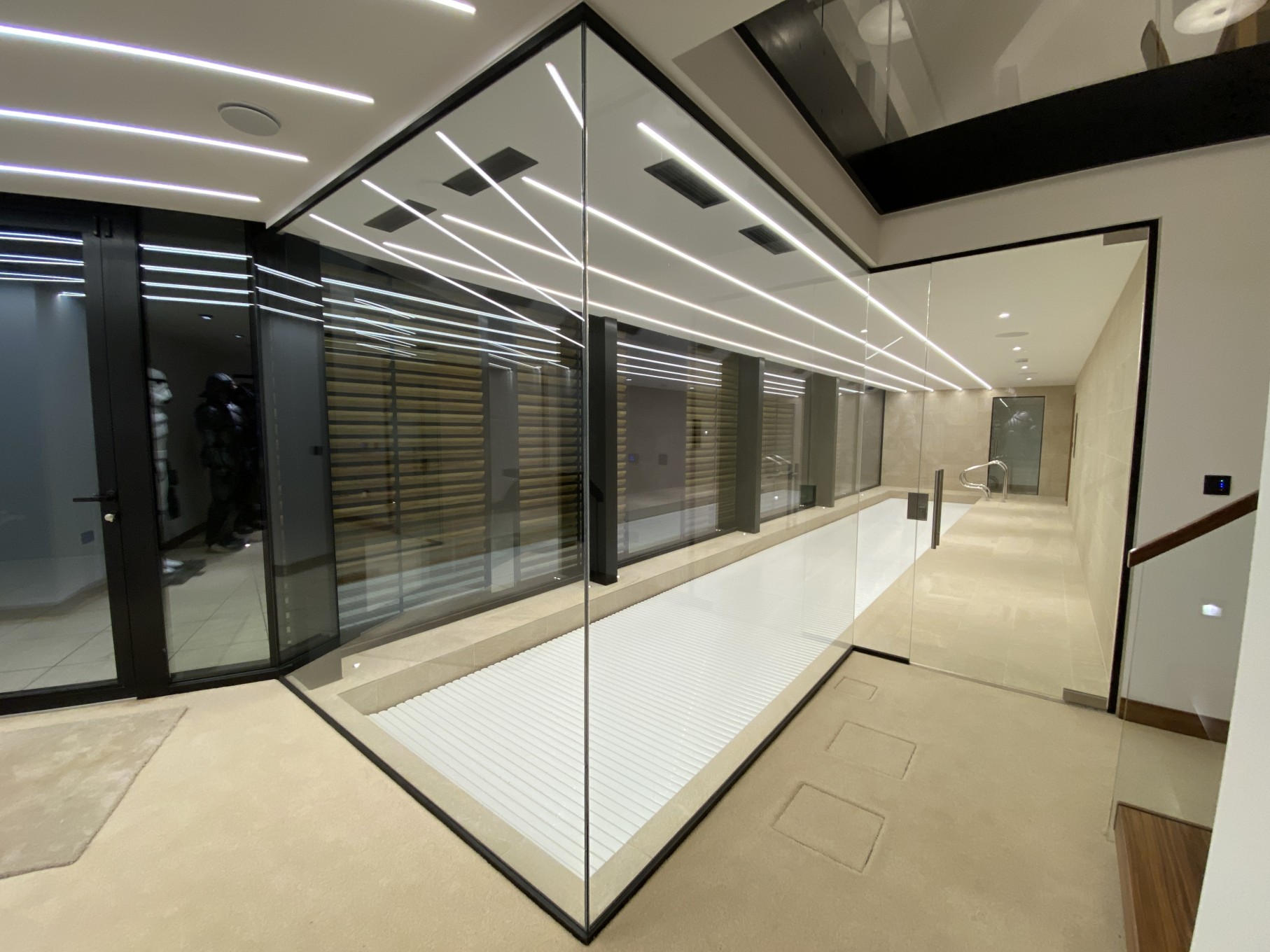 Pool area with glass panels showcasing in-built lighting