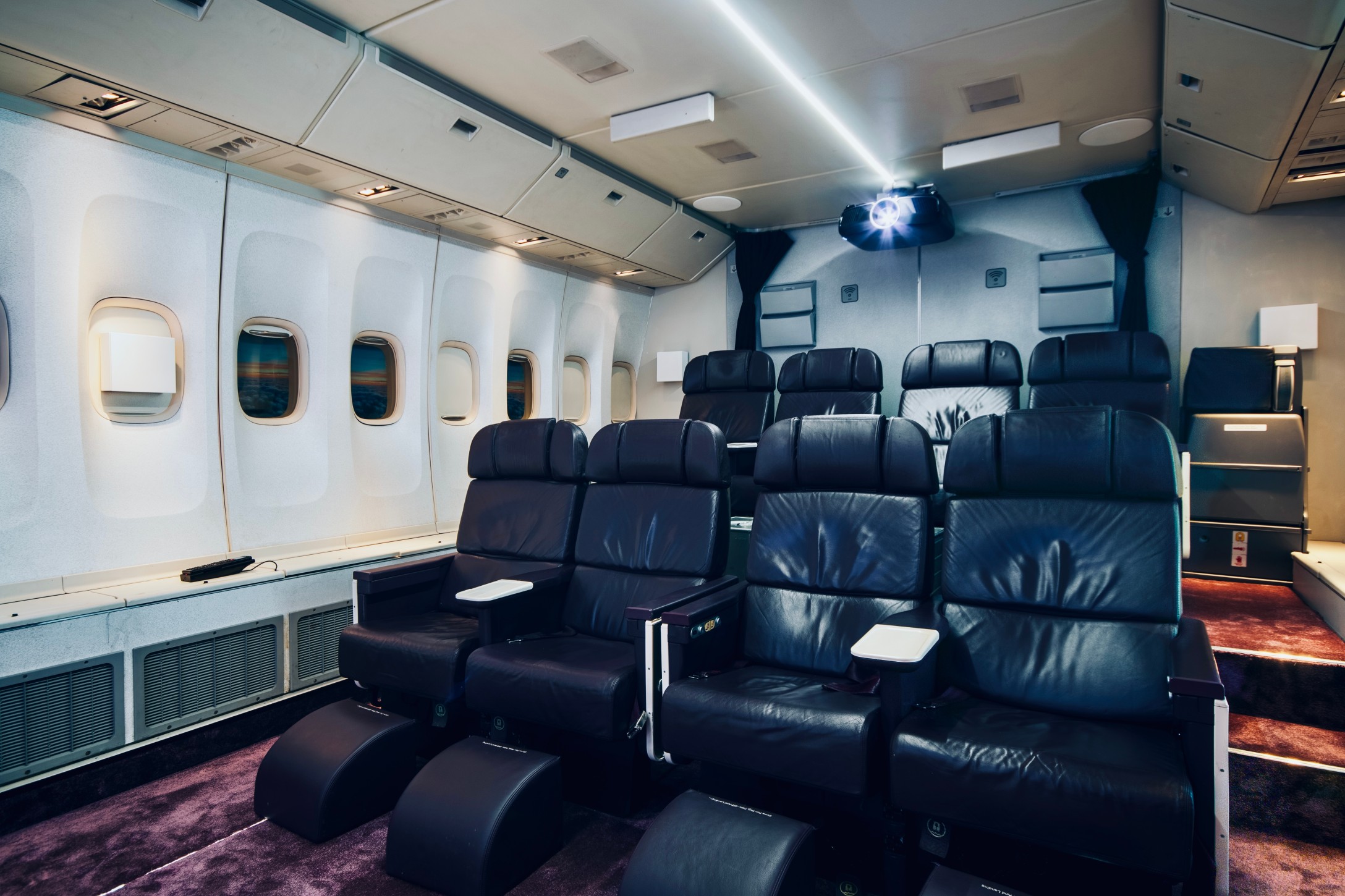Angle of Home Cinema room made from decommissioned aircraft showing aircraft cinema chairs and projector