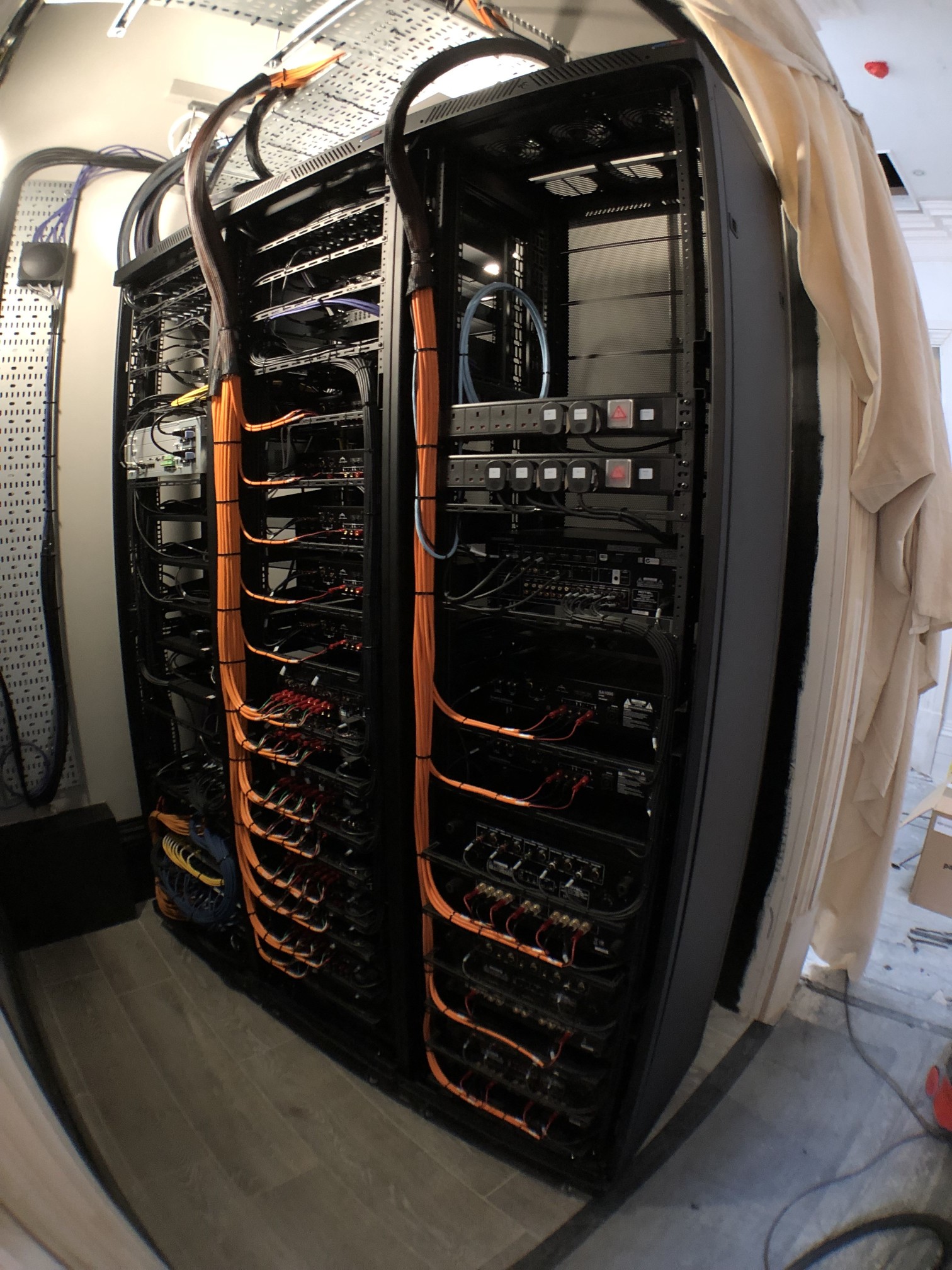 Fisheye lens of a open multimedia AV rack with network, audio and video connections that are cable-tied and optimised